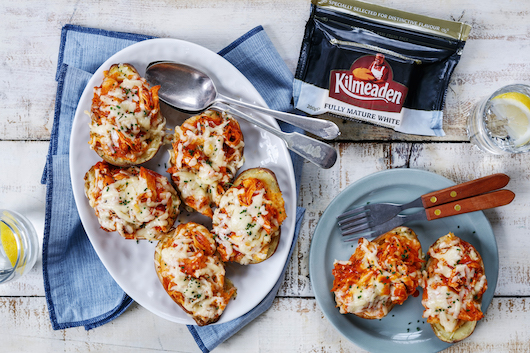 Twice baked cheddar cheese and buffalo chicken potatoes on two plates using Kilmeaden Fully Mature White Cheddar Cheese.