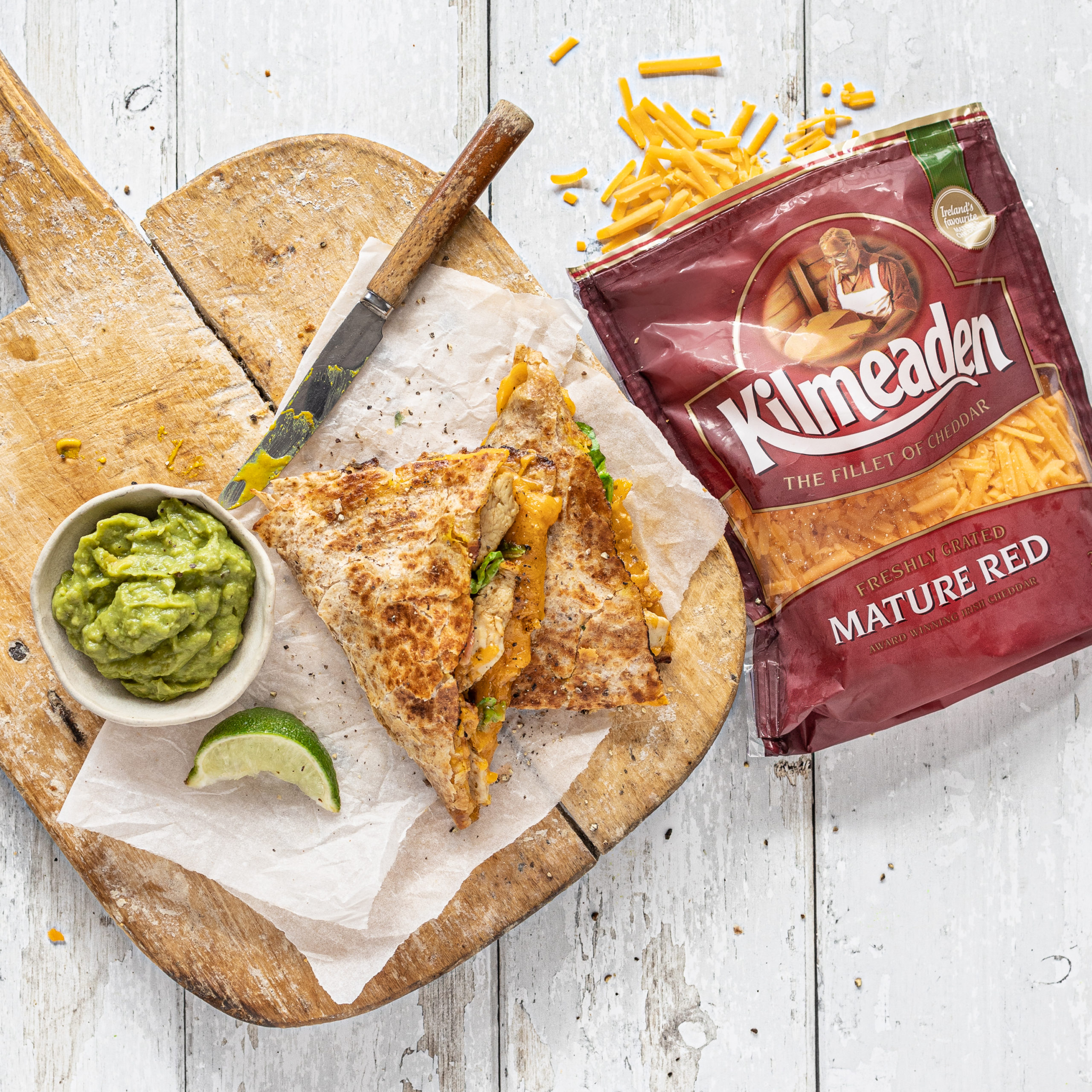 Folded Crispy Cheese and Chicken Wraps with guacamole and lime on the side,